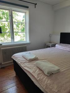 Östra Flygeln Grinda Säteri في Malmköping: غرفة نوم عليها سرير ووسادتين