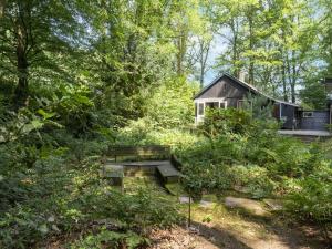 una casa en el bosque con un banco y árboles en Tranquil holiday home in Epse with sauna, en Epse