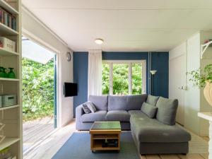 Sala de estar azul con sofá y mesa en Tranquil holiday home in Epse with sauna, en Epse