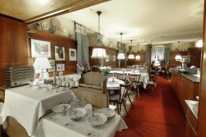 黑林山區舍瑙的住宿－Hotel Kirchbühl，一间设有白色桌椅的用餐室和一间带桌子的房间