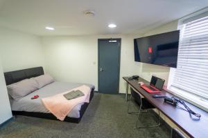 um quarto com uma cama e uma secretária com um computador portátil em Ground floor studio close to the city! em Birmingham