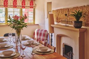 a dining room with a table with a fireplace at Coniston House - Eco Hot Tub in Stow on the Wold