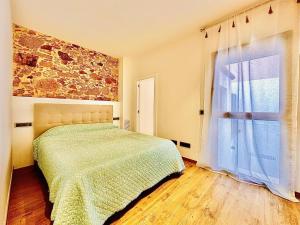 um quarto com uma cama e uma grande janela em Ca La Nineta em Sant Feliu de Guíxols