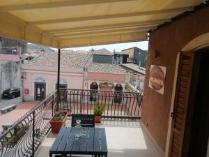 einen Balkon mit einem Tisch und Blick auf ein Gebäude in der Unterkunft La perla di nicolosi in Nicolosi