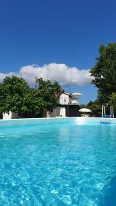 una piscina de agua azul frente a una casa en La Dolce Vita, en Castelfidardo