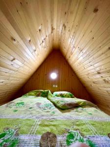 Šavnik的住宿－Apartman Kurjak，木制客房的一张床位,设有木制天花板
