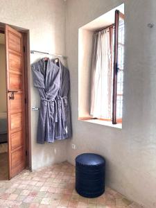 Zimmer mit einem Fenster und einer blauen Ottomane in der Unterkunft Riad Rossi in Marrakesch