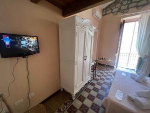 a room with a tv on the wall and a table at Corso 41 in Bosa