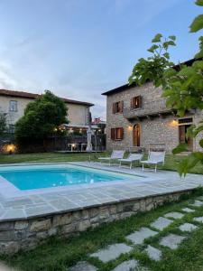 a swimming pool in front of a stone house at “Da Paolino” in Borgo alla Collina