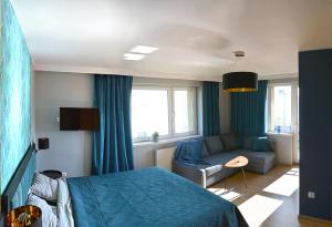 a bedroom with a blue bed and a couch at Bursztynek in Stegna