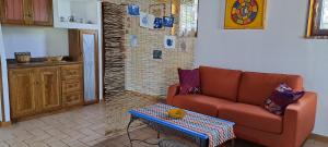 un soggiorno con divano e tavolo di "La casetta" indipendente, con ampio spazio verde a Fontechiari