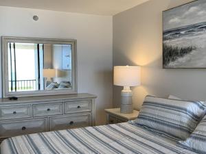 - une chambre avec un lit et une commode avec un miroir dans l'établissement Beach Front Apartment Overlooking the Gulf, à Clearwater Beach