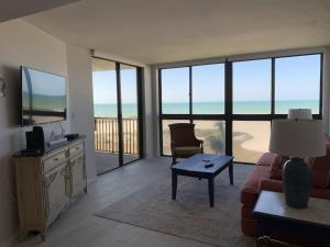 uma sala de estar com um sofá e uma mesa com uma televisão em Beach Front Apartment Overlooking the Gulf em Clearwater Beach