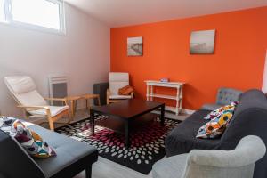 a living room with two couches and an orange wall at Gite de la Baie - Morgat in Crozon