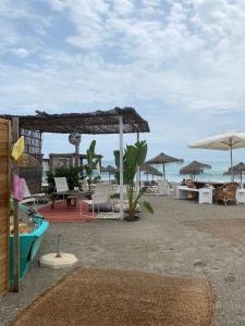 a beach with chairs and umbrellas and the ocean at Marina de Casares Suites in San Luis de Sabinillas