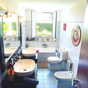 ein Badezimmer mit zwei Waschbecken, einem WC und einer Badewanne in der Unterkunft Maresole tra l'Etna e Taormina in Mascali