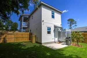 a white house with a fence in a yard at La Casa Boheme in Pensacola