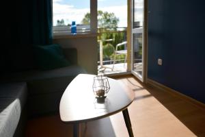 a coffee table in a living room with a window at Bursztynek in Stegna