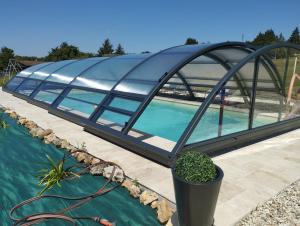 a glass building with a pool in the middle at Villa du Cerf Thibault in Le Blanc