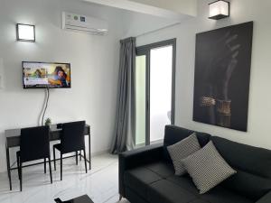 a living room with a black couch and a table at Giorgis Luxury Apartments in Ayia Napa