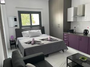 Giorgis Luxury Apartments في أيا نابا: غرفة نوم بسرير كبير ومطبخ
