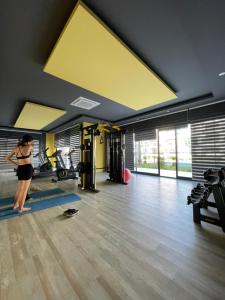 a woman is exercising in a gym with a yellow ceiling at Calypso Residence Kestel in Alanya