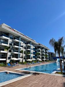 a swimming pool in front of a large apartment building at Calypso Residence Kestel in Alanya