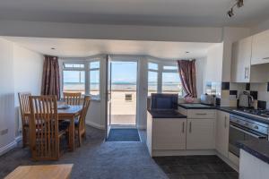 a kitchen with a table and a dining room at Deluxe Kipling Villa with Sea Views in Bideford