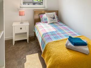 a small bedroom with a bed and a night stand at Castle Park in Ceres