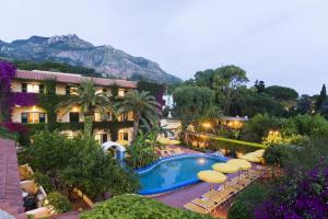 a resort with a pool and chairs and umbrellas at Villa Angela Hotel & Spa in Forio d'Ischia