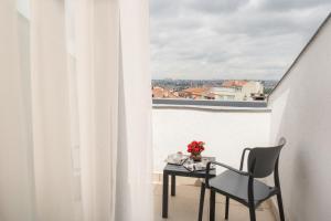 a table and a chair on a balcony with a window at Elm Suite Hotel in Istanbul
