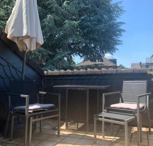 eine Terrasse mit 2 Stühlen und einem Sonnenschirm in der Unterkunft Ruhige Wohnung an der Uni in Düsseldorf