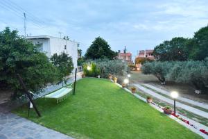 a view of a lawn with trees and lights at Xenophon House in Paleo Tsifliki +37 photos