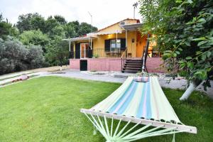 a hammock in a yard in front of a house at Xenophon House in Paleo Tsifliki