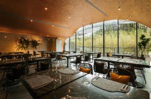 een restaurant met tafels en stoelen en een groot raam bij 了了礁溪 Vivir Jiaoxi Hotel in Jiaoxi