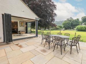 a patio with a table and chairs on it at Beech Lea in Ulverston