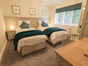 a bedroom with two beds and a window at Beech Lea in Ulverston