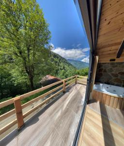 a balcony with a tub and a view of the mountains at Ayder Çalıkuşu Bungalov in Ayder Yaylasi