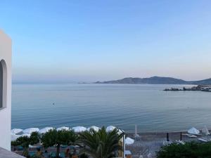 a view of a large body of water with umbrellas at Haraki Bay Hotel and Luxury Apartments in Haraki