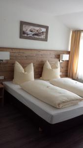 2 Betten mit weißer Bettwäsche und Kissen im Schlafzimmer in der Unterkunft Hotel Alte Krone in Tübingen