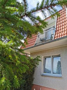 una casa con balcone e alberi in primo piano di Dom Sonia a Niechorze