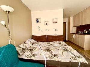 a bedroom with a bed and a blue couch at Kitas krantas in Juodkrantė