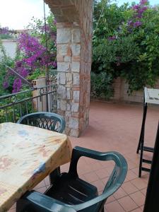 una mesa y sillas en un patio con flores en Residence La Playa, en Marina di Camerota