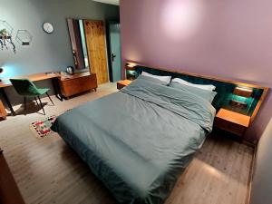 ein Schlafzimmer mit einem großen Bett und einem Schreibtisch mit einem Stuhl in der Unterkunft Piro's Cozy Rooms - City Centre in Korçë