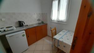 a small kitchen with a sink and a table and a window at Avli Studios in Kokkino Nero
