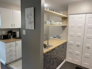 a kitchen with white cabinets and a sink at Les Condos de la Montagne 1 in Beaupré
