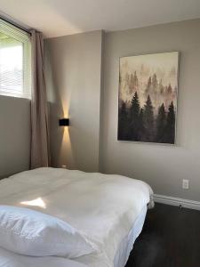 a bedroom with a bed and a painting on the wall at Les Condos de la Montagne 1 in Beaupré