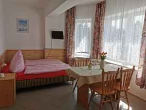 a bedroom with a small bed and a table with a tableablish at Dom Sonia in Niechorze