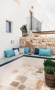 a patio with blue pillows on a stone wall at Masseria Auraterrae in Polignano a Mare
