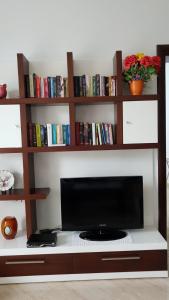 un televisor sentado en la parte superior de un estante con libros en Cheerful 3-Bedroom Private Villa in Borsh! en Borsh